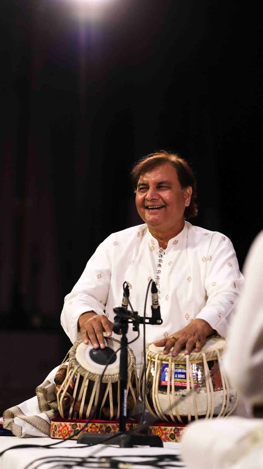Ustad Akram Khan in white, laughing at the tabla