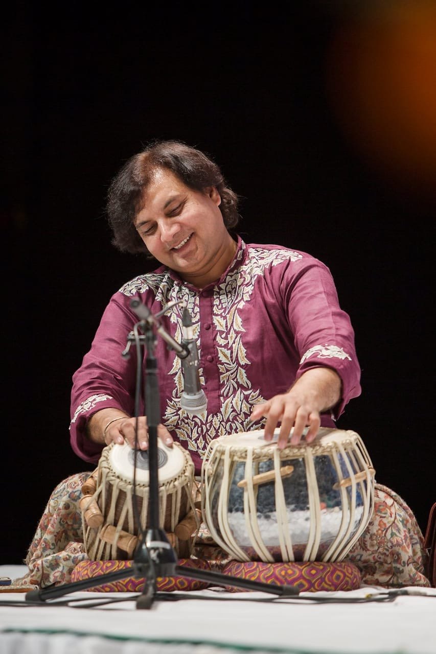 Ustad Akram Khan in a maroon kurta playing tabla