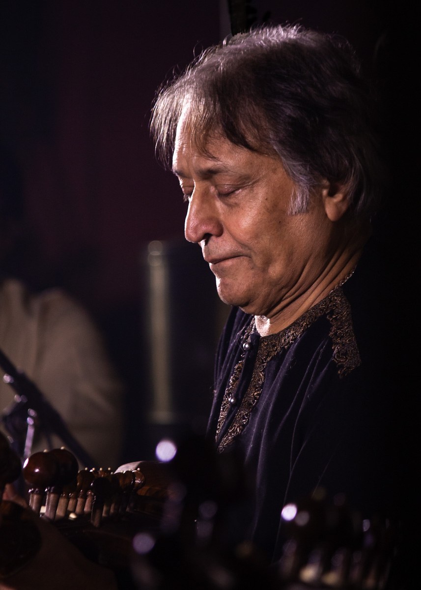 Amjad Ali Khan seated with the sarod resting on his lap, playing in concert.