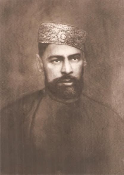 Sepia studio portrait of Bande Ali Khan wearing an embroidered cap.