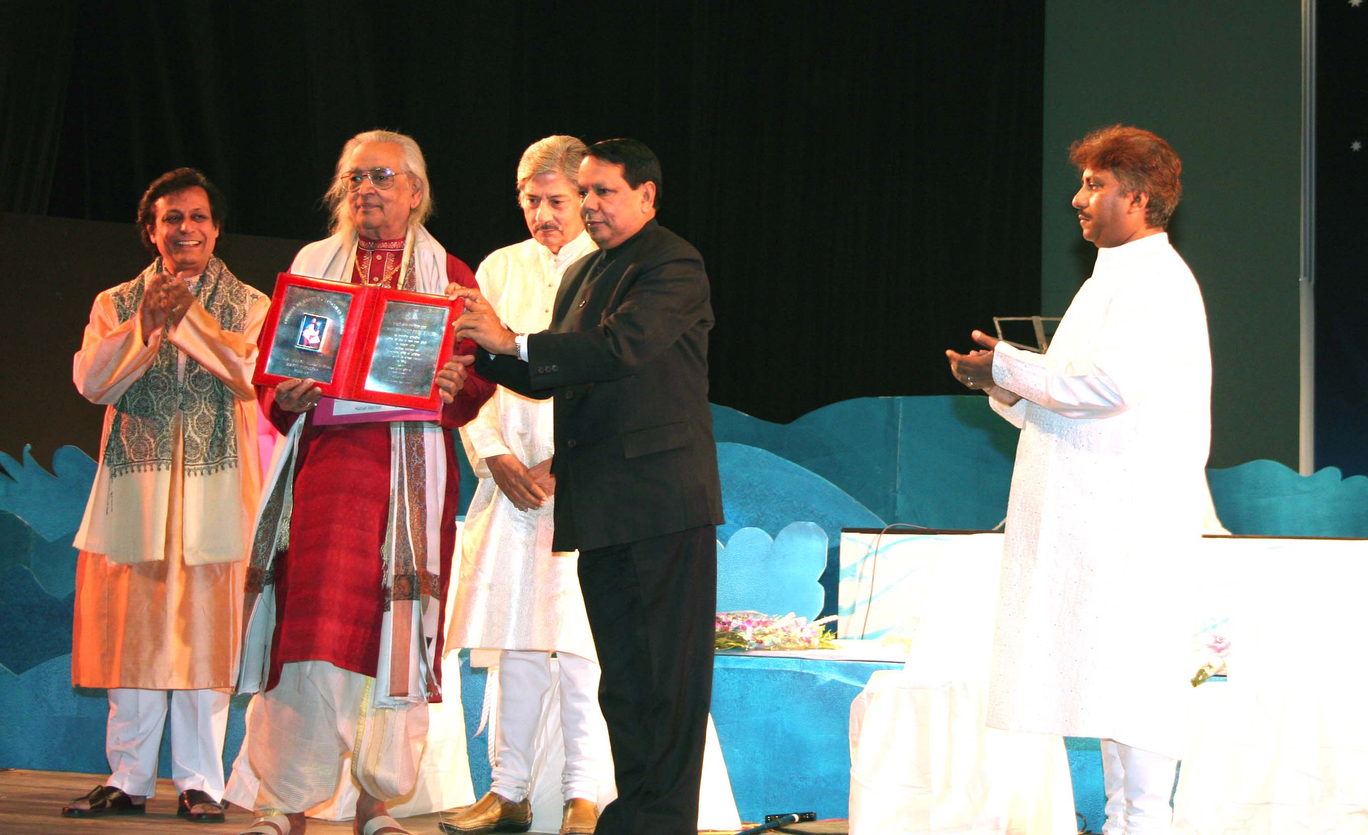 Pandit Kishan Maharaj receiving a lifetime achievement award on stage in Calcutta, 2006